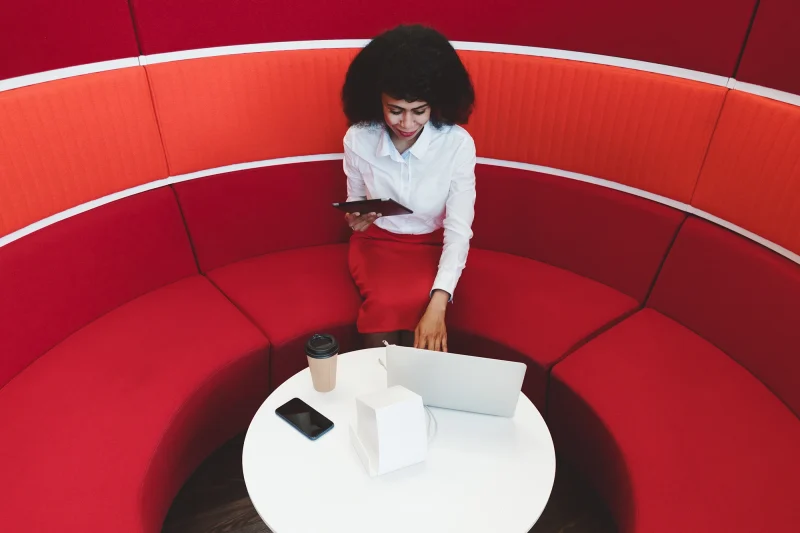 gallery_woman_working_on_red_couch